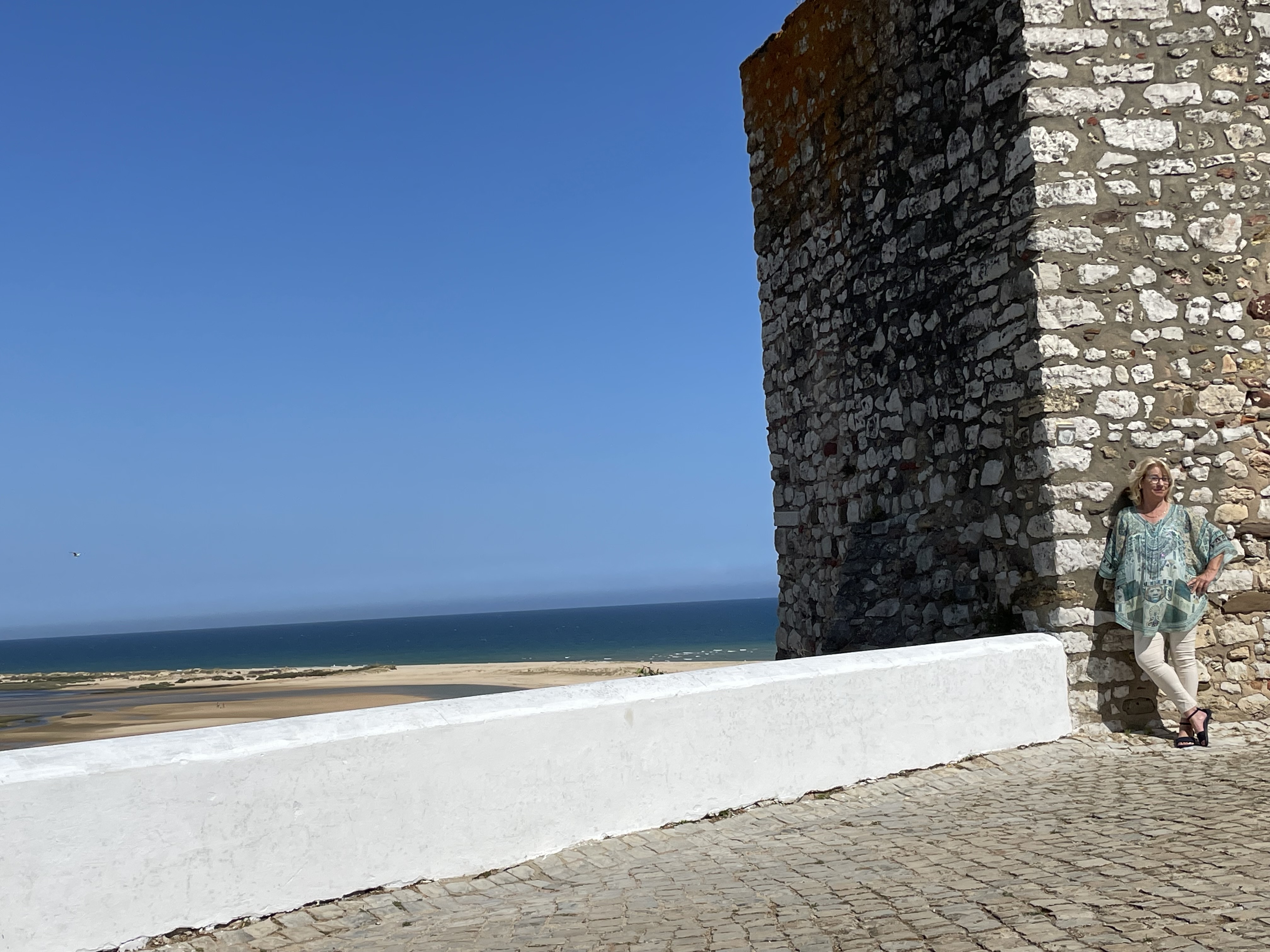 Bettina Haskamp an einer alten Festungsmauer an der Algarve-Küste